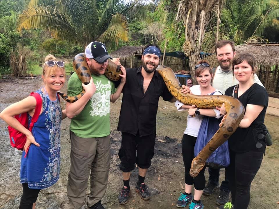 Group of people holding an anaconda