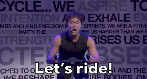 Saturday Night Live character saying Let's Ride while on a bike.