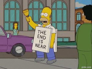 Homer Simpson walking down the street ringing a bell and wearing a sign that reads, "The end is near."