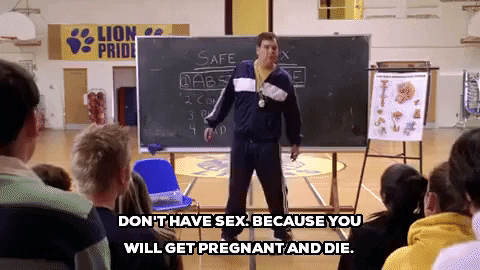 Coach Carr standing in front of a blackboard saying, "Don't have sex because you will get pregnant and die."