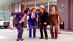 A group of anchormen jumping together in excitement.